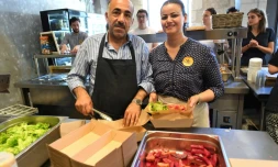 Jawad (g) et Zainab Al-Khajee, couple de journalistes irakiens réfugiés en France, préparent des plats irakiens, le 23 juin 2018 dans le snack de Darwin, un espace associatif sur les bords de la Garonne, à Bordeaux