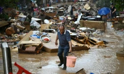 Un habitant récupÚre de l'eau de pluie dans une zone inondée aprÚs la rupture d'un réservoir prÚs de Gantang, dans la région du Guangxi, le 9 juillet 2026 dans le sud-ouest de la Chine