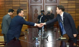 Kim Ki-Woong (d), haut responsable du ministÚre sud-coréen de l'Unification serre la main de son homologue nord-coréen, lors d'une rencontre à Panmunjom, le 26 novembre 2015 dans la zone démilitarisée entre les deux Corées