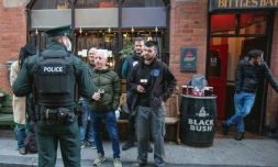 Un policier s'entretient avec les clients d'un bar à Belfast, en Irlande du Nord, le 16 octobre 2020