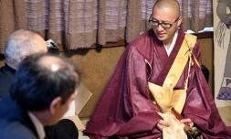Kaichi Watanabe, un moine bouddhiste (D) s'entretient avec des particuliers lors d'une cérémonie à domicile à Funabashi, une banlieue de Tokyo le 10 novembre 2016
