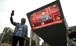 Une femme prend un selfie devant un écran sur lequel est retransmis le discours du président chinois Xi Jinping à l'occasion du centenaire du parti communiste chinois, à Pékin le 1er juillet 2021