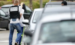 Un policier arrĂȘte un homme aprĂšs une perquisition Ă Saint-Etienne-du-Rouvray, le 26 juillet 2016