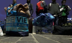 Des migrants ramassent leurs affaires, se préparant à quitter leur camp de fortune près de la gare d'Austerlitz à Paris, le 17 septembre 2015