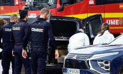 La police se tient devant des équipes médico-légales alors qu'elles chargent une victime dans une camionnette des pompes-funÚbres la suite des inondations dévastatrices à Alfafar, dans la région de Valence, dans l'est de l'Espagne, le 4 novembre 2024