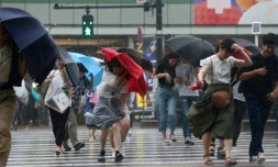 Les passants à Tokyo se protègent de la pluie provoquée par le typhon Jongdari, le 28 juillet 2018