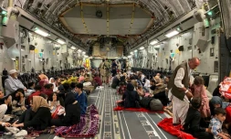 Des Afghans s'installent dans un avion militaire américain qui va les évacuer d'Afghanistan, à l'aéroport de Kaboul, le 19 août 2021