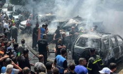 Des secouristes et des habitants sur le site d'une frappe aérienne israélienne qui a touché une voiture à Saïda, le 10 juin 2026 au Liban