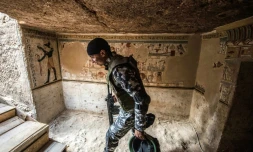 Un membre des forces de sécurité égyptiennes à l'entrée d'une tombe datant de 2.000 ans dévoilée le 5 avril 2019 à Akhmim