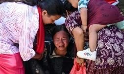Une femme s’effondre tandis qu’elle attend l’arrivée de ses proches dans un camp militaire après avoir été secourue des zones touchées par des crues subites, dans la ville de Battar Bazar, dans le district de Nuwakot au Népal, le 27 août 2026