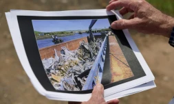 Dennis Diggins montre la photo d'une barge transportant en 2001 des débris du World Trade Center à Fresh Kills, le 28 mai 2021 à Staten Island