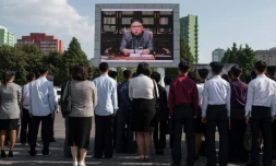 Des spectateurs écoutent la lecture d'une déclaration du dirigeant nord-coréen Kim Jong-Un devant un écran géant installé près de la gare de Pyongyang le 22 septembre 2017.