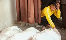 Un Palestinien se recueille devant les corps de ses proches tués dans une frappe aérienne israélienne dans le sud de la ville de Gaza, le 11 mars 2025
