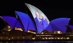 Un portrait du roi Charles III et de la reine Camilla projecté sur la façade de l'Opéra de Sydney, le 18 octobre 2024 en Australie