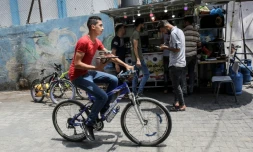 Un jeune homme livre des cafés à vélo près du marché de Rafah, dans la bande de Gaza, le 13 juillet 2020