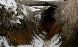 Un soldat ukrainien marche dans une tranchée près de la ligne de front avec les séparatistes pro-russes dans la région de Donetsk le 31 janvier 2022