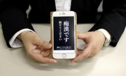 Un responsable de la police tient un téléphone contenant l'application "Digi police", à Tokyo, le 13 mai 2019