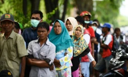 Des habitants de la zone touchée par le séisme et le tsunami font la queue pour recevoir une aide, le 4 octobre 2018 à Palu, en Indonésie