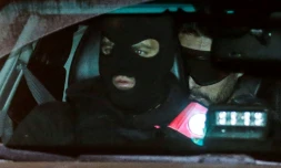 Le jihadiste français Mehdi Nemmouche (D), accusé d'avoir tué quatre personnes en 2014 au Musée juif de Bruxelles, arrive assis à l'arrière d'une voiture de police à une audience préliminaire à Bruxelles, le 20 décembre 2018