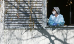 Un membre du personnel soignant se repose quelques minutes à la fenêtre de l'hôpital Emile Muller à Mulhouse, le 24 mars 2020 