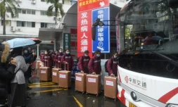 Des personnels médicaux montent à bord d'un bus à destination de Hong Kong pour apporter leur aide face à l'augmention des cas de Covid-19, le 19 février 2022 à Canton, dans le sud de la Chine
