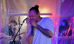 Le Français Frédéric Yonnet, virtuose de l'harmonica, avec sa formation de quatre membres, séparés par des bùches en plastique, joue pour les habitants du quartier de Capitol Hill, le 3 mai 2020 à Washington