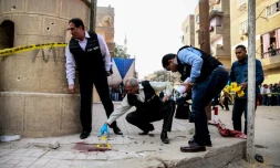 Des membres des forces de sécurité inspectent le site d'une attaque contre une église au sud du Caire le 29 décembre 2017