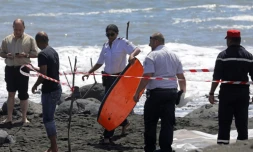 Un policier emporte le bodyboard du jeune homme tué par un requin le 21 février 2017 à Saint-André à La Réunion