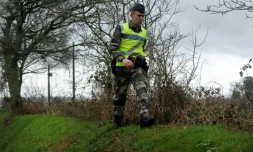 Un gendarme à la recherche d'indices le 3 mars 2017 sur une route à Dirinon