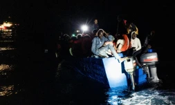 Des migrants s'apprêtent à embarquer sur l'Ocean Viking dans les eaux internationales près de Malte pour être pris en charge par l'association humanitaire SOS Méditerranée en pleine nuit, le 25 octobre 2022