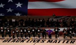 Membres des Los Angeles Lakers et des LA Clippers agenouillés devant le mot d'ordre "Black lives matter" et durant l'hymne américain avant leur match de NBA, le 30 juillet 2020 à Lake Buena Vista (Floride)