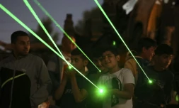 Des manifestants palestiniens à Beita en Cisjordanie projettent des rayons lasers verts vers la colonie Eviatar, installée sur une colline, le 23 juin 2021