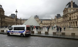 Un véhicule de police garé devant la pyramide du Louvre à Paris le 4 février 2017