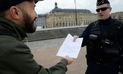 Un policier contrôle le laisser-passer d'un habitant à Bordeaux, le 17 mars 2020. Le confinement de la population est un moyen important de lutte contre la propagation de l'épidémie de coronavius 