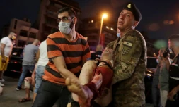 Un soldat libanais et un homme transportent un blessé à l'hôpital après les explosions le 4 août 2020