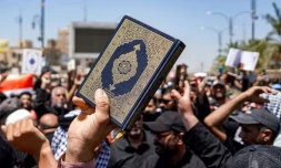 Des manifestants brandissent le Coran durant une manifestation après la prière du vendredi à Kufa, près de Najaf, en Irak