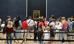 Des visiteurs protégés par des masques devant "Mona Lisa", le tableau de Léonard de Vinci dans une des salles du musée du Louvre, le 6 juillet 2020
