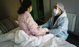 Le docteur Ozkaya (d) réconforte une patiente qui récupÚre aprÚs avoir été malade du Covid-19, dans un hÎtel à Chelles reconverti en centre de traitement, le 22 avril 2020