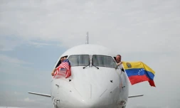 Les pilotes du vol 3599 d'American Airlines, reliant l'aéroport international de Miami à Caracas, au Venezuela, agitent des drapeaux vénézuéliens et américains avant de décoller pour un vol direct vers le Venezuela, le premier entre les États-Unis et le Venezuela en sept ans, le 30 avril 2026 à l'aéroport international de Miami, en Floride
