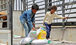 Des enfants portent des rations alimentaires dans un camp de déplacés, dans la province de Hodeida, le 29 mars 2022 au Yémen