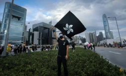 Un manifestant agite un drapeau hongkongais noir au lieu du rouge officiel, le 1er juillet 2019