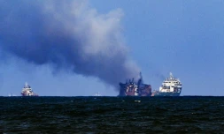 Un bateau de la société néerlandaise Smit remorque le porte-conteneurs MV X-Press Pearl (c), ravagé par un incendie depuis douze jours, pour l'éloigner des cÎtes de Colombo, le 2 juin 2021 au Sri Lanka