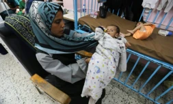 Une jeune mère palestinienne berce son bébé souffrant de malnutrition à l'hôpital Nasser de Khan Younès, dans le sud de la bande de Gaza, le 24 juillet 2025