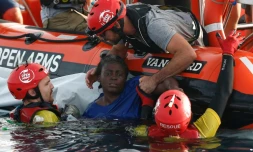 Les membres de l'ONG Proactiva repâchent une femme en Méditerranée à à environ 80 milles nautiques au nord-est de Tripoli le 17 juillet 2018