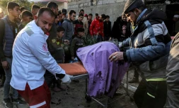 Des secouristes évacuent les corps des victimes d'une frappe israélienne qui a détruit une voiture de police, le 6 février 2024 à Rafah, dans le sud de la bande de Gaza