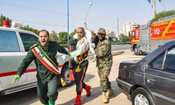 Un homme porte un soldat blessé lors d'une attaque à Ahvaz, dans le sud-ouest de l'Iran, le 22 septembre 2018