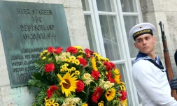 Un soldat allemand près d'une plaque à la mémoire des officiers fusillés pour leur implication dans l'attentat contre Hitler en 1944, au mémorial de la résistance allemande à Berlin le 20 juillet 2014
