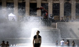 Des jeunes se rafraîchissent dans une fontaine de l'esplanade du Trocadéro à Paris, le 24 juin 2019