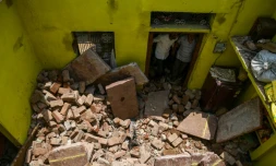 Des voisins regardent le plafond qui s'est effondré sur Sunil Kumar, 24 ans, lors d'une tempête à Kheragarh dans les environs d'Agra, en Inde le 4 mai 2018.