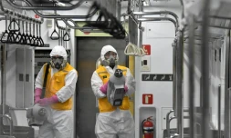 Des employés en combinaison de protection désinfectent une rame du métro de Séoul en Corée du Sud, pour se prémunir du nouveau coronavirus, le 11 mars 2020